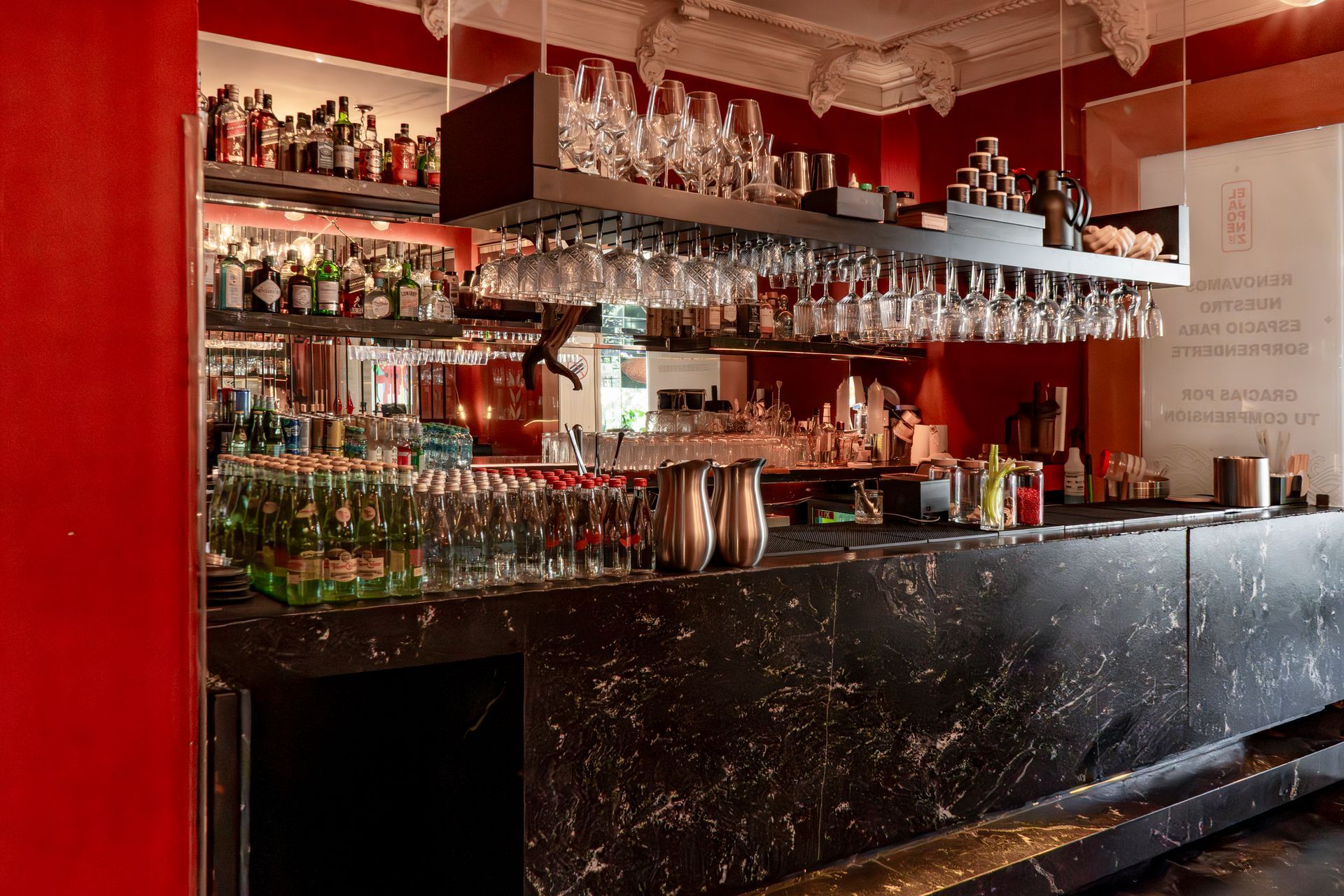 Bar acogedor: barra de mármol y paredes rojas.
