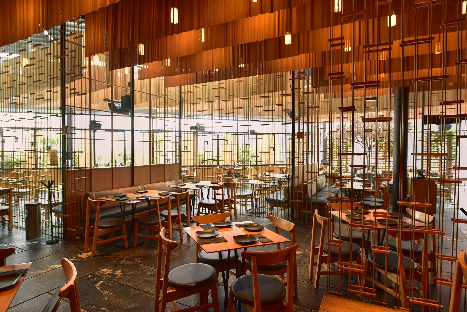 Restaurante moderno con mesas redondas y grandes ventanales.