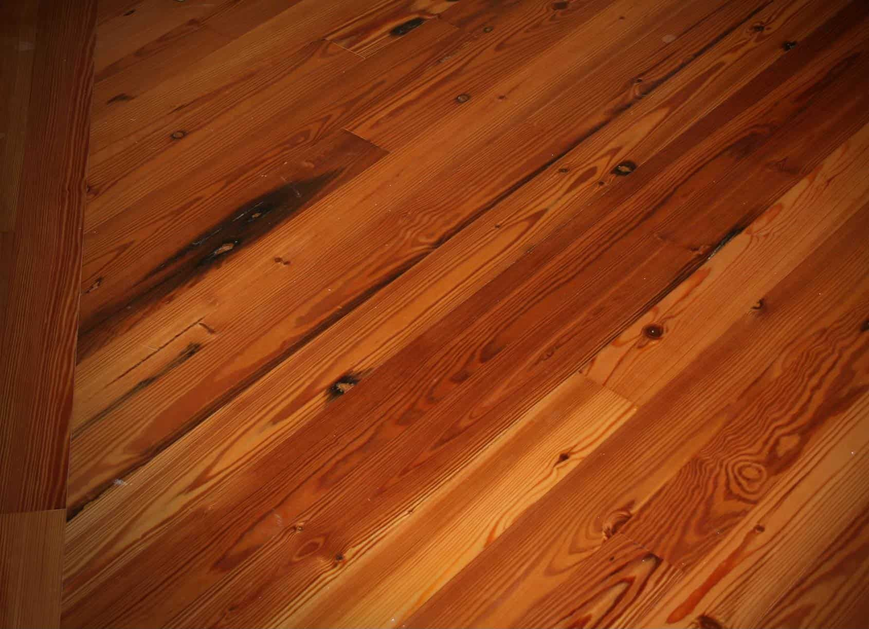 Wooden floorboards with a diagonal pattern in shades of brown.
