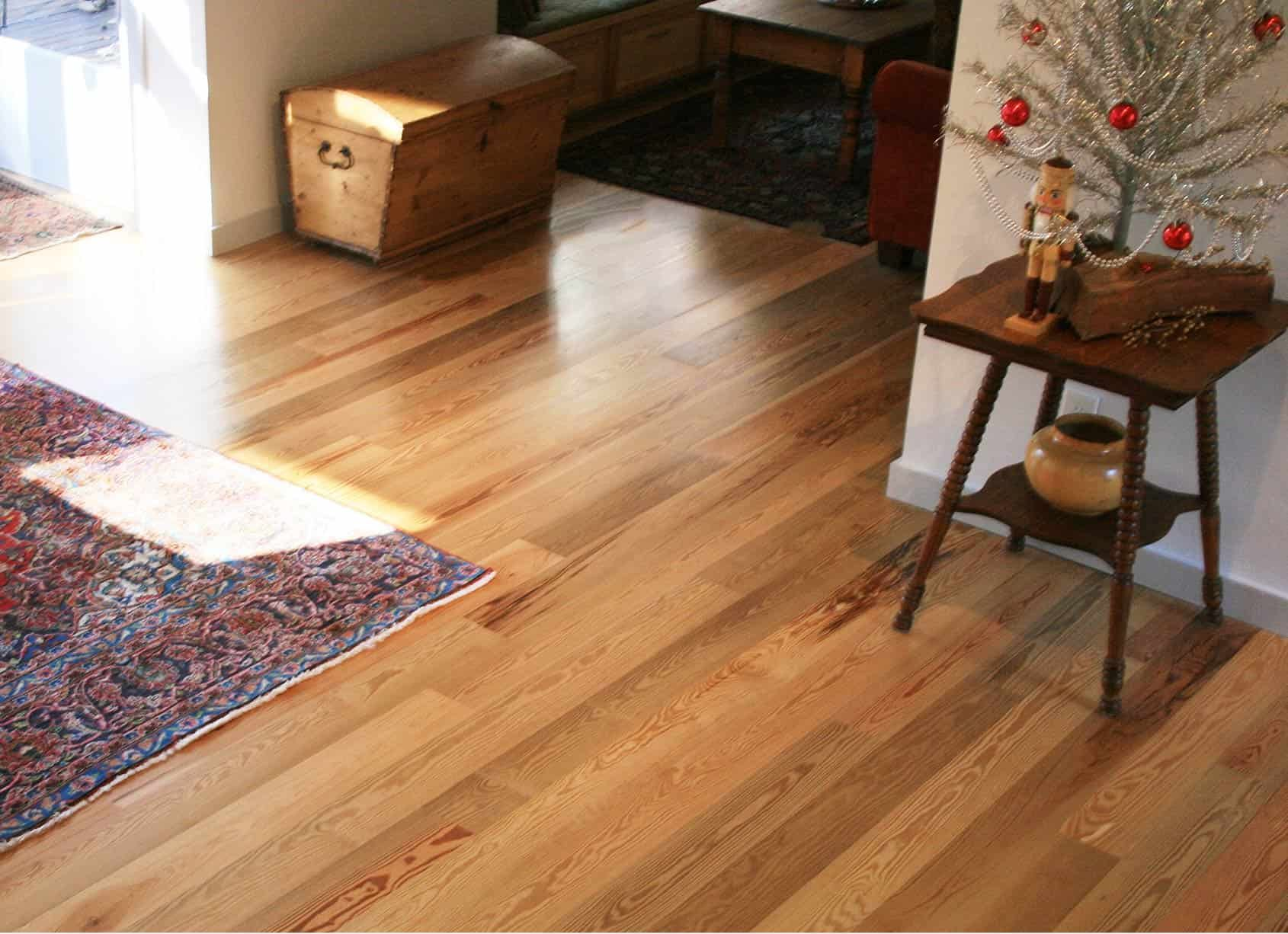 Wooden floor, rug, and side table with decorations; trunk visible in the background.