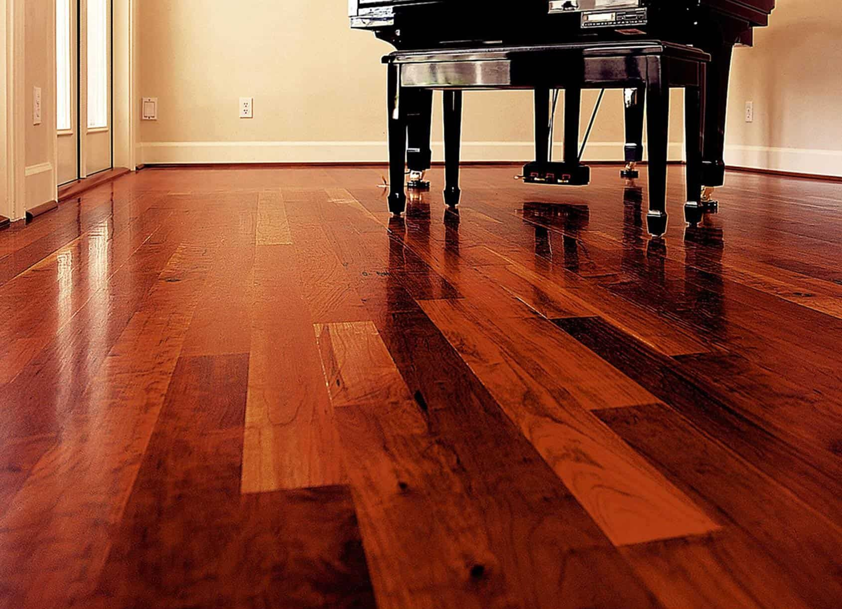 Glossy hardwood floor with a grand piano in the background.