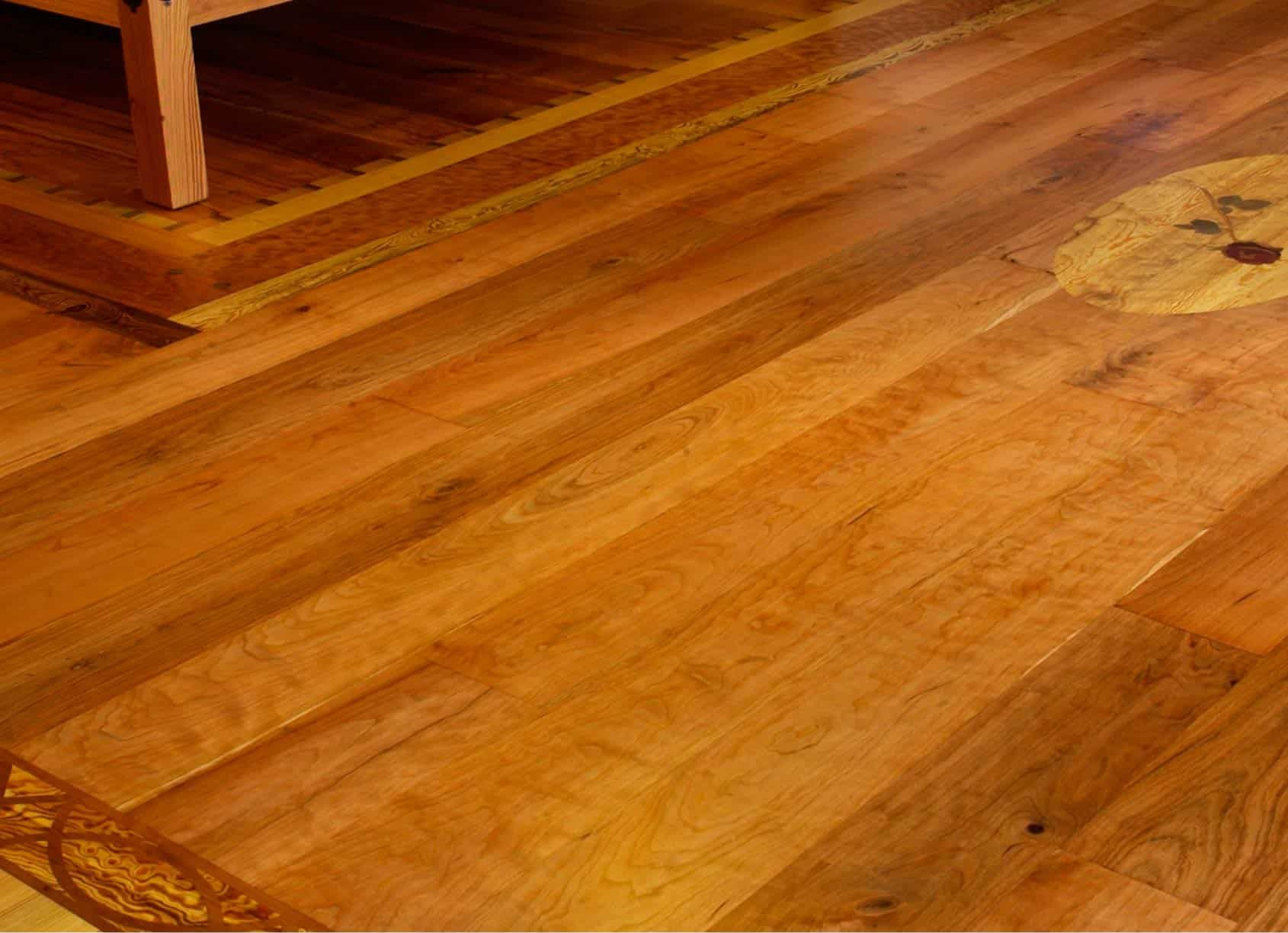 Wooden floor with natural grain, various shades of brown. Border and decorative circle inlaid.