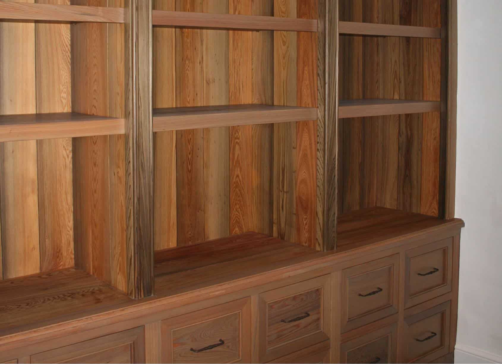 Wooden built-in shelving unit with open shelves above drawers.