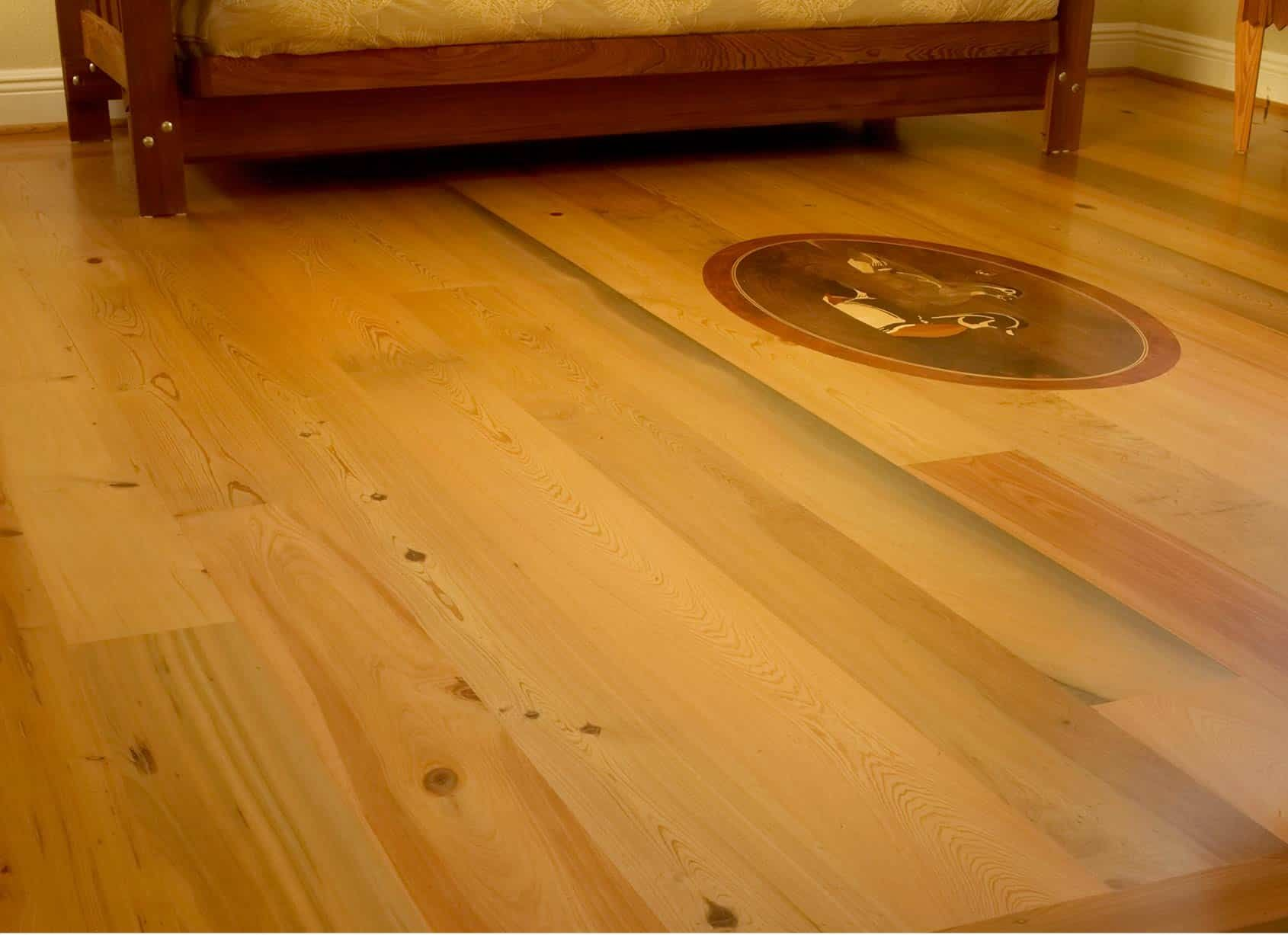Wooden floor with built-in decorative circle.  A wooden bed frame is in the background.