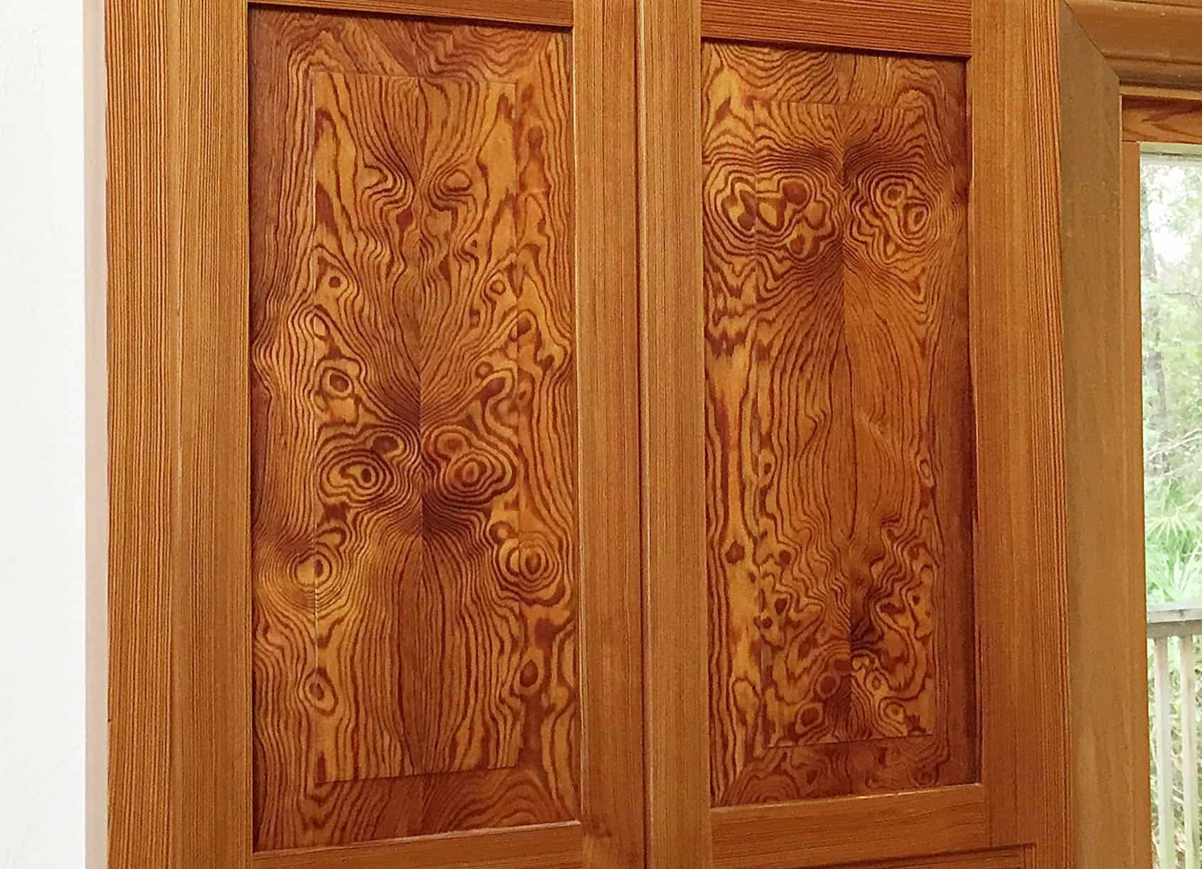 Two wooden cabinet doors with intricate grain patterns, framed in darker wood.