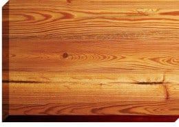 Close-up of a wood grain surface in shades of brown and tan, showing natural patterns and knots.