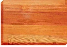 Wooden cutting board, showing warm tones of orange and brown wood grain.
