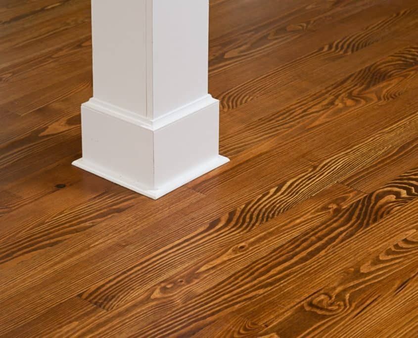 Wooden floorboards with a white square pillar base.