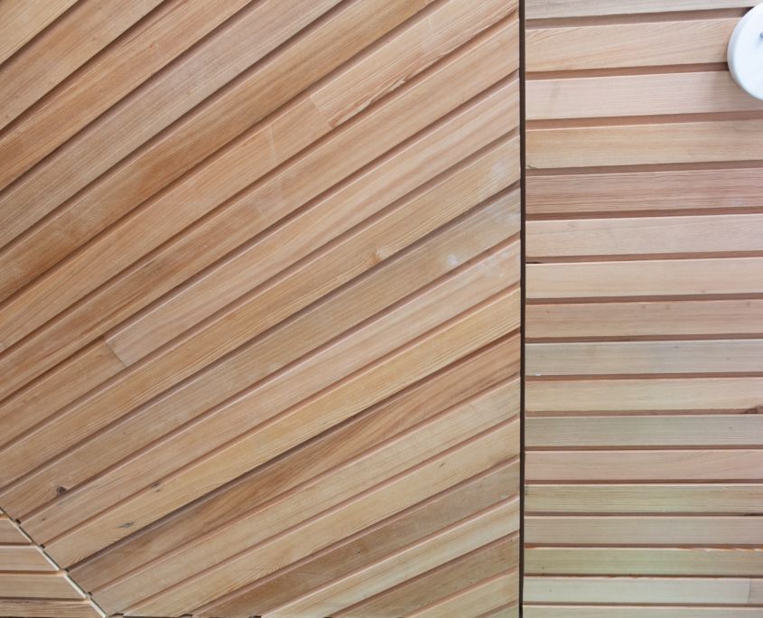 Angled wood paneling, with horizontal wood paneling on the right. Smoke detector visible.