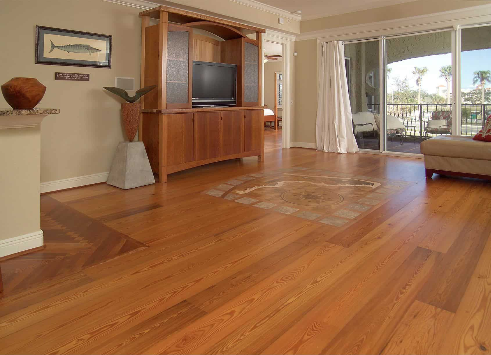 Wooden floor in a living room, with a TV cabinet, a sliding glass door to a balcony, and a decorative vase.