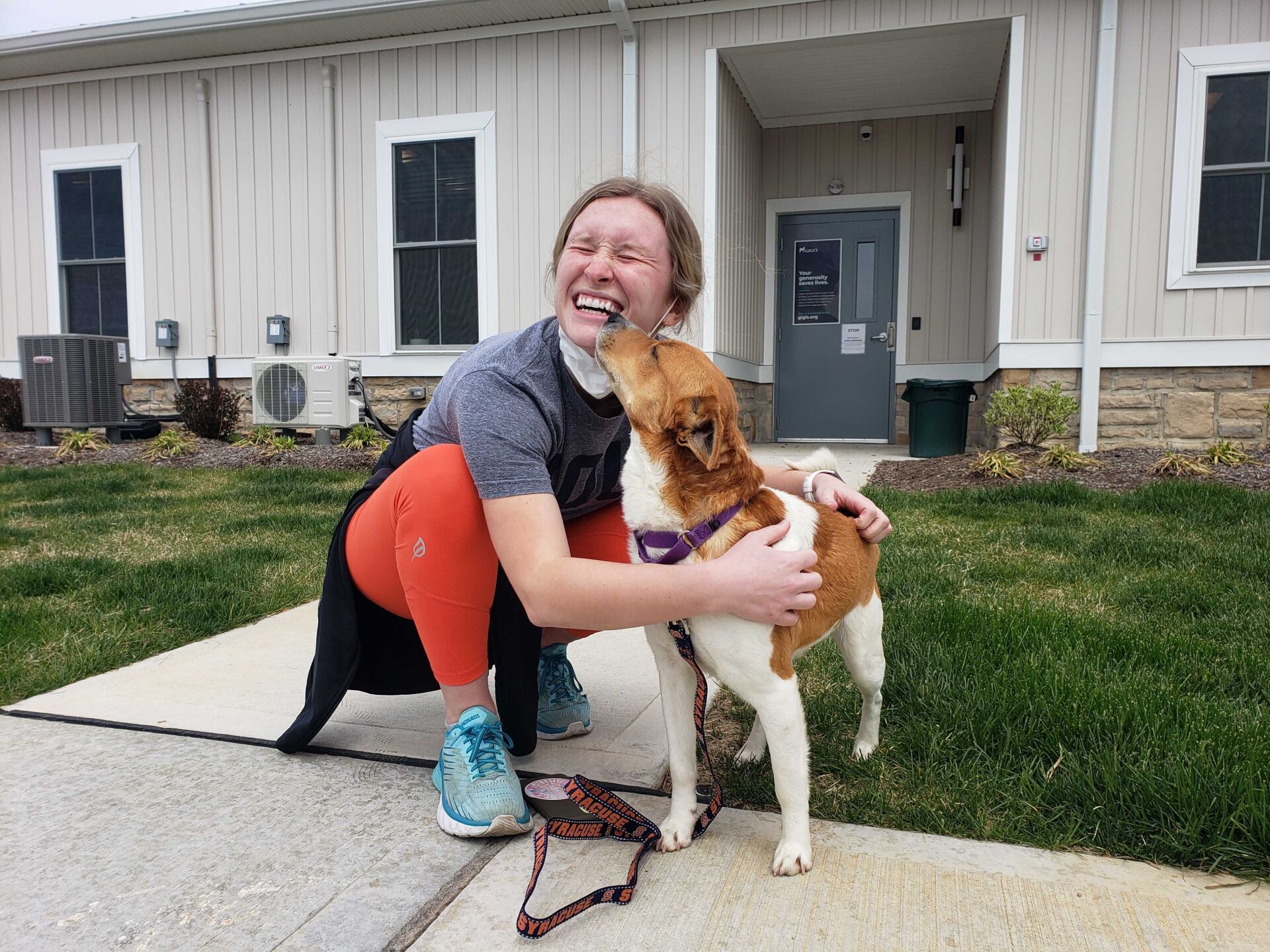 Girl bent over giving kisses to dog | Gigi's Shelter for Dogs | Trinity In The Community  | Trinity Homes | Columbus, Ohio 43231