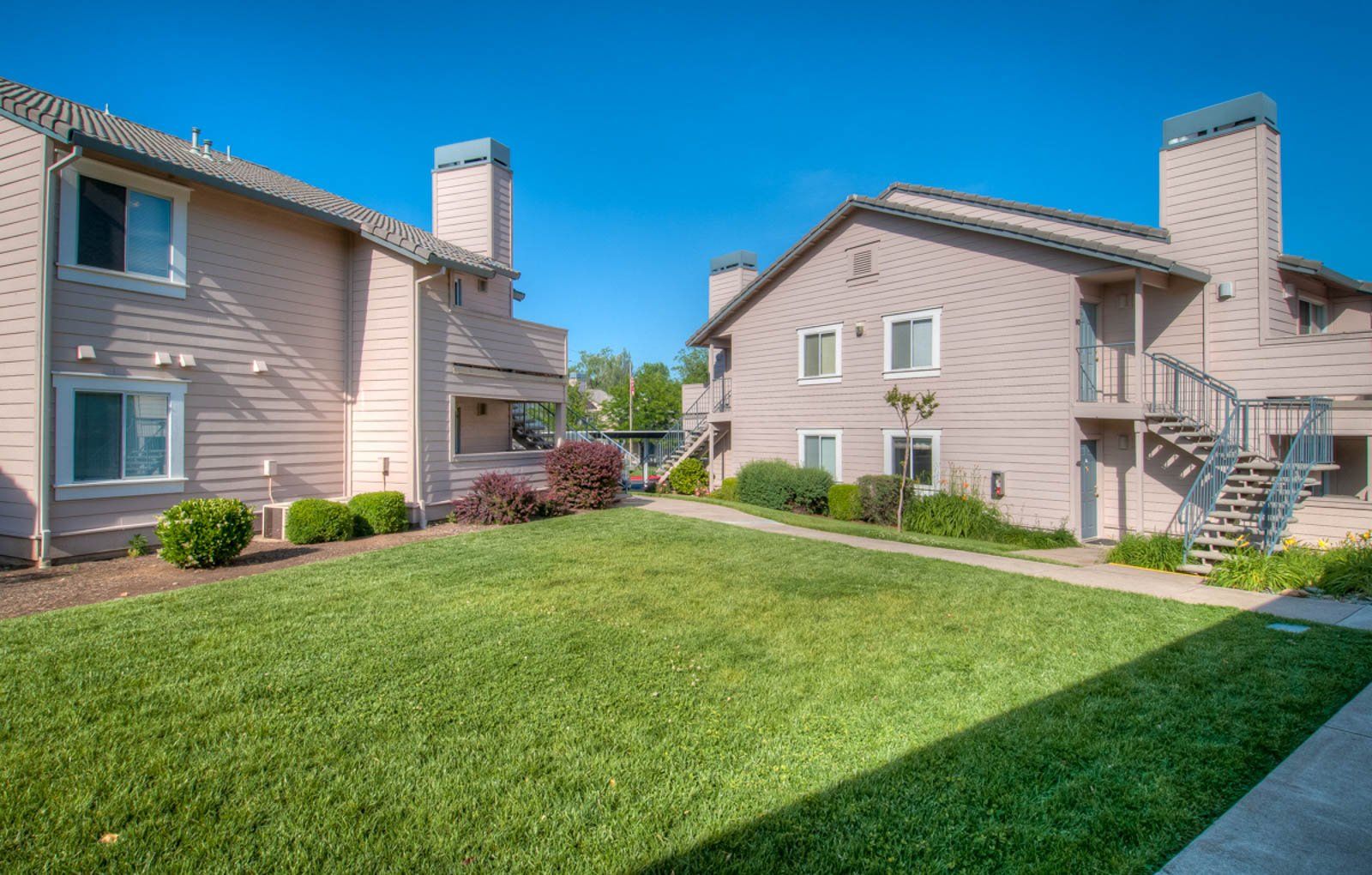 Exterior view of Shasta Creek Apartments with large grassy area between buildings