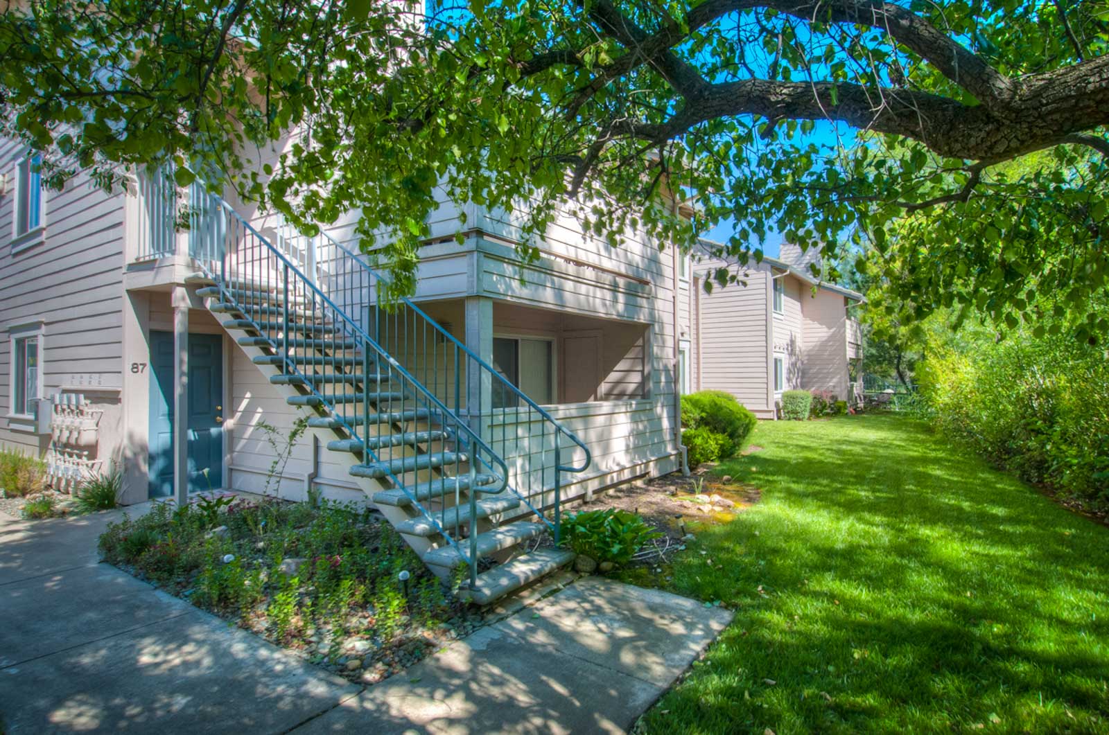 Shasta Creek Apartments exterior stair case next two a grassy shaded area