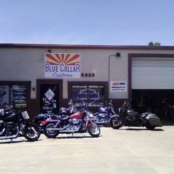 Four motorcycles parked outside the Blue Collar Customs shop, which features an Arizona-themed logo and the address 8859.