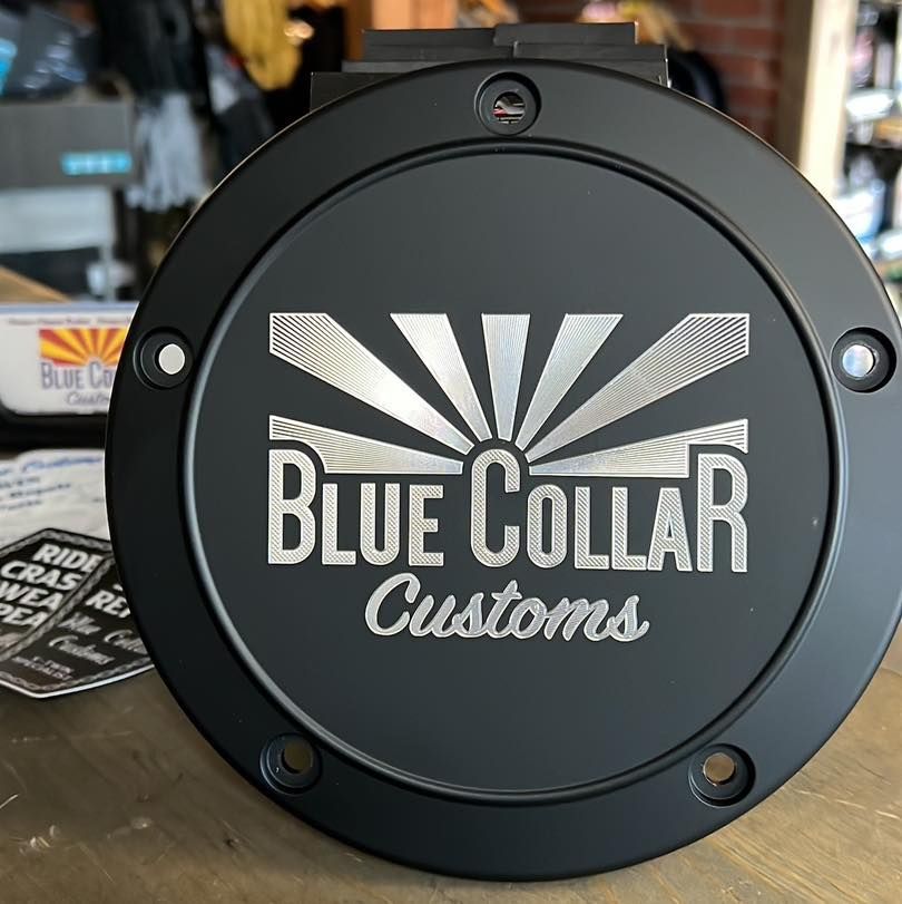 A black, circular custom gas cap engraved with the 