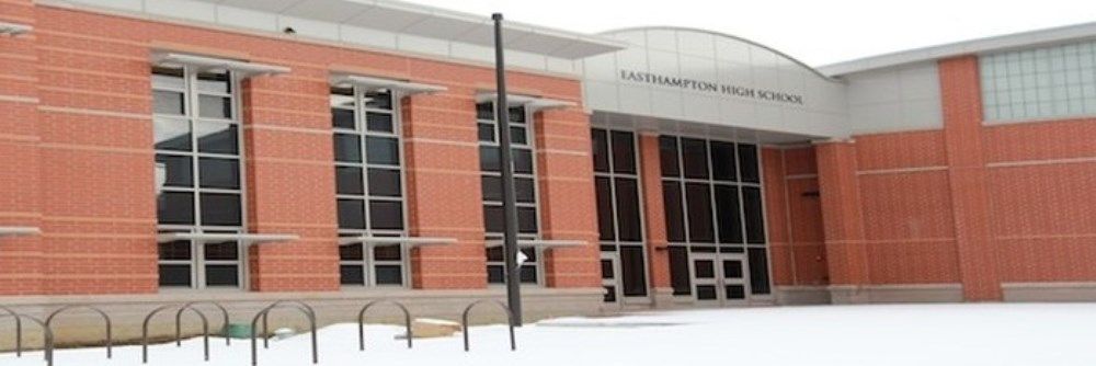 A large brick building with a lot of windows is covered in snow.