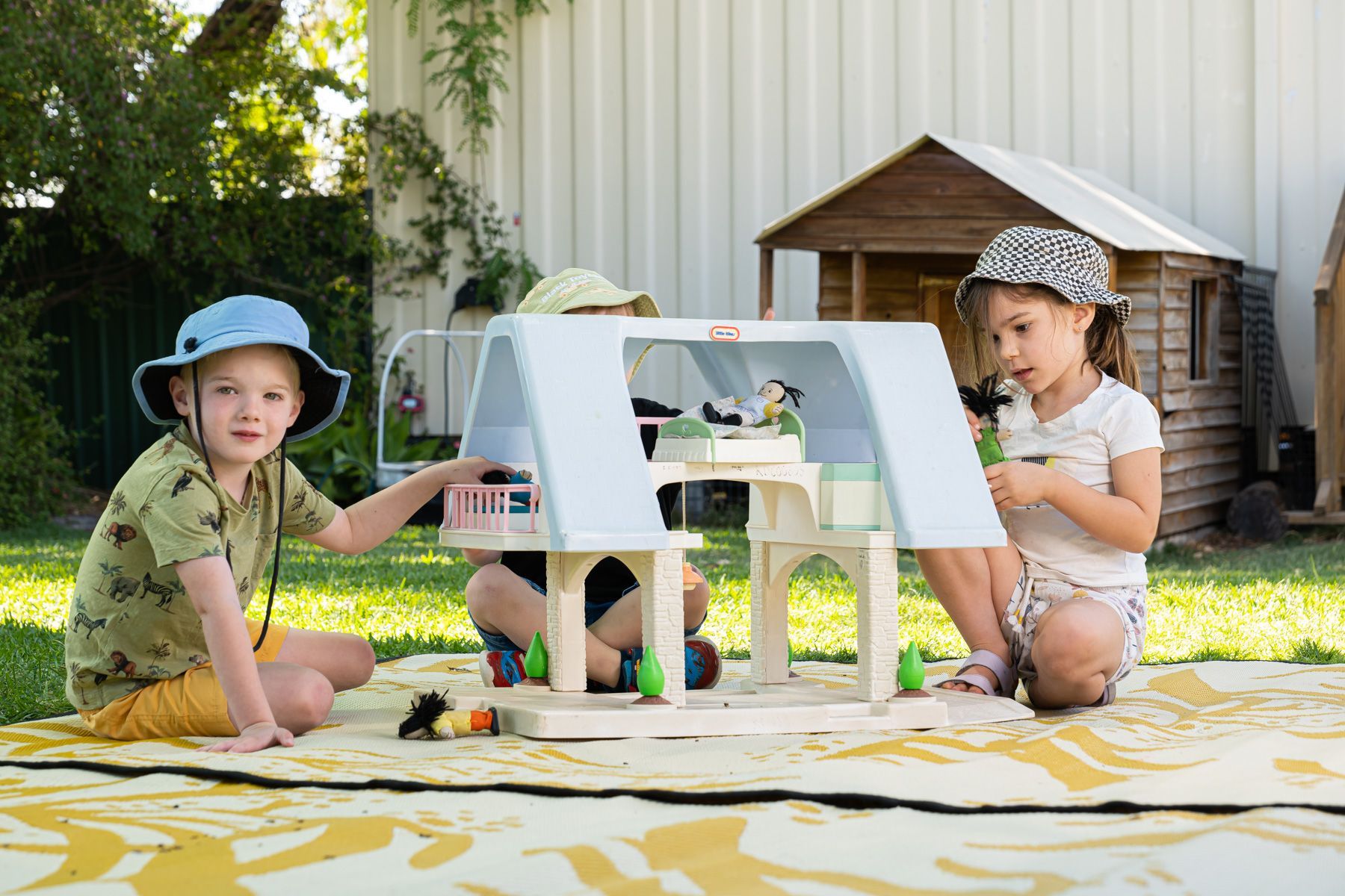 Two children playing with a dolls house