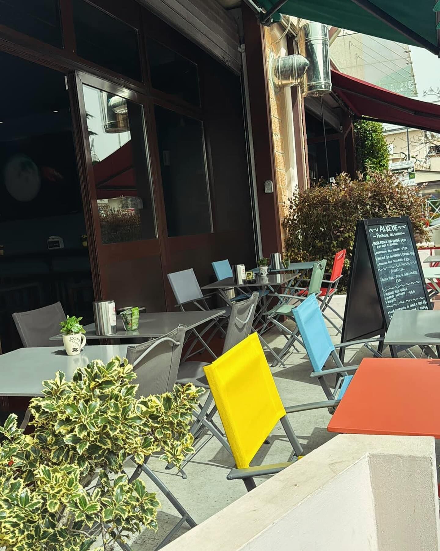 Una fila di tavoli e sedie all'esterno del ristorante Alkeme