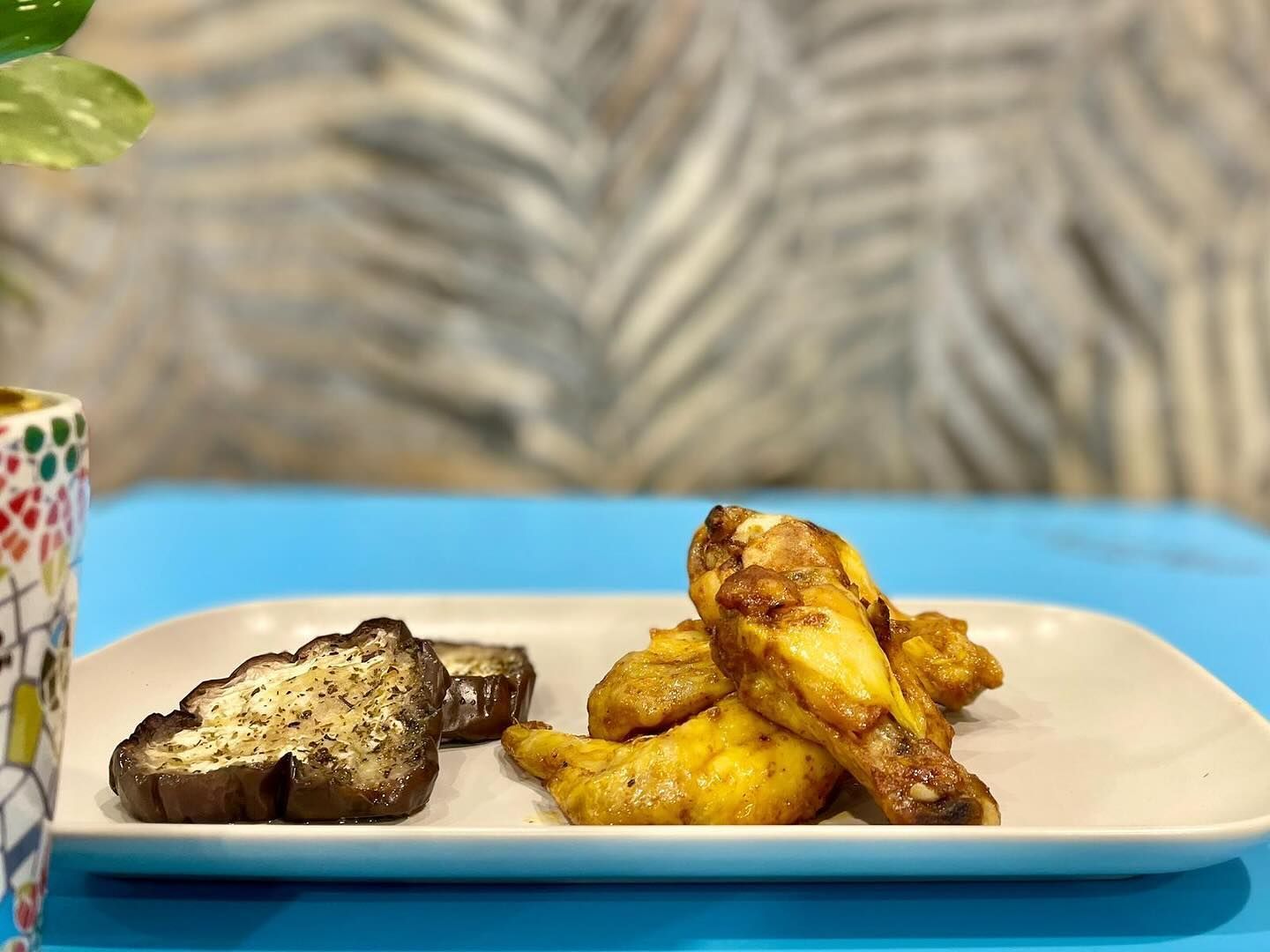 ali di pollo e toast francese su un tavolo blu.