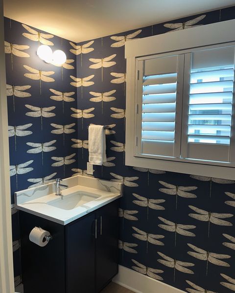 A bathroom with a toilet , sink and mirror.