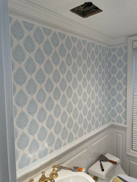 A bathroom with a sink and a window with shutters