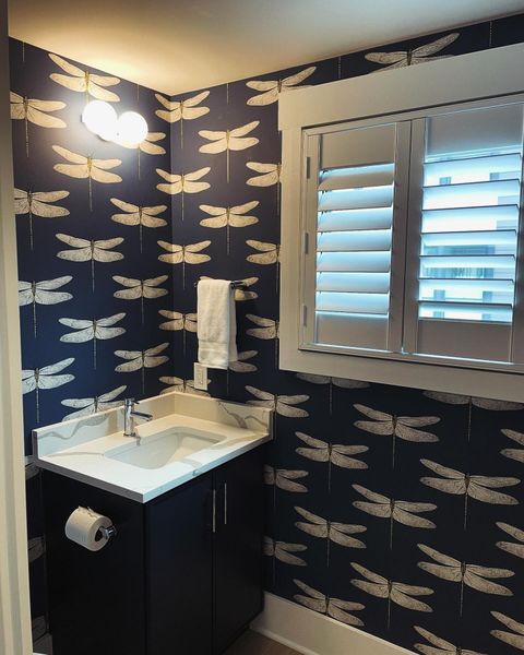 A bathroom with a sink and a window with shutters