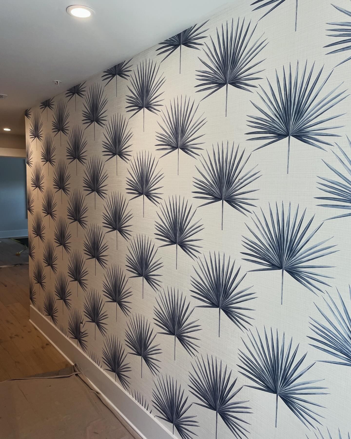 A wall with a pattern of palm leaves on it