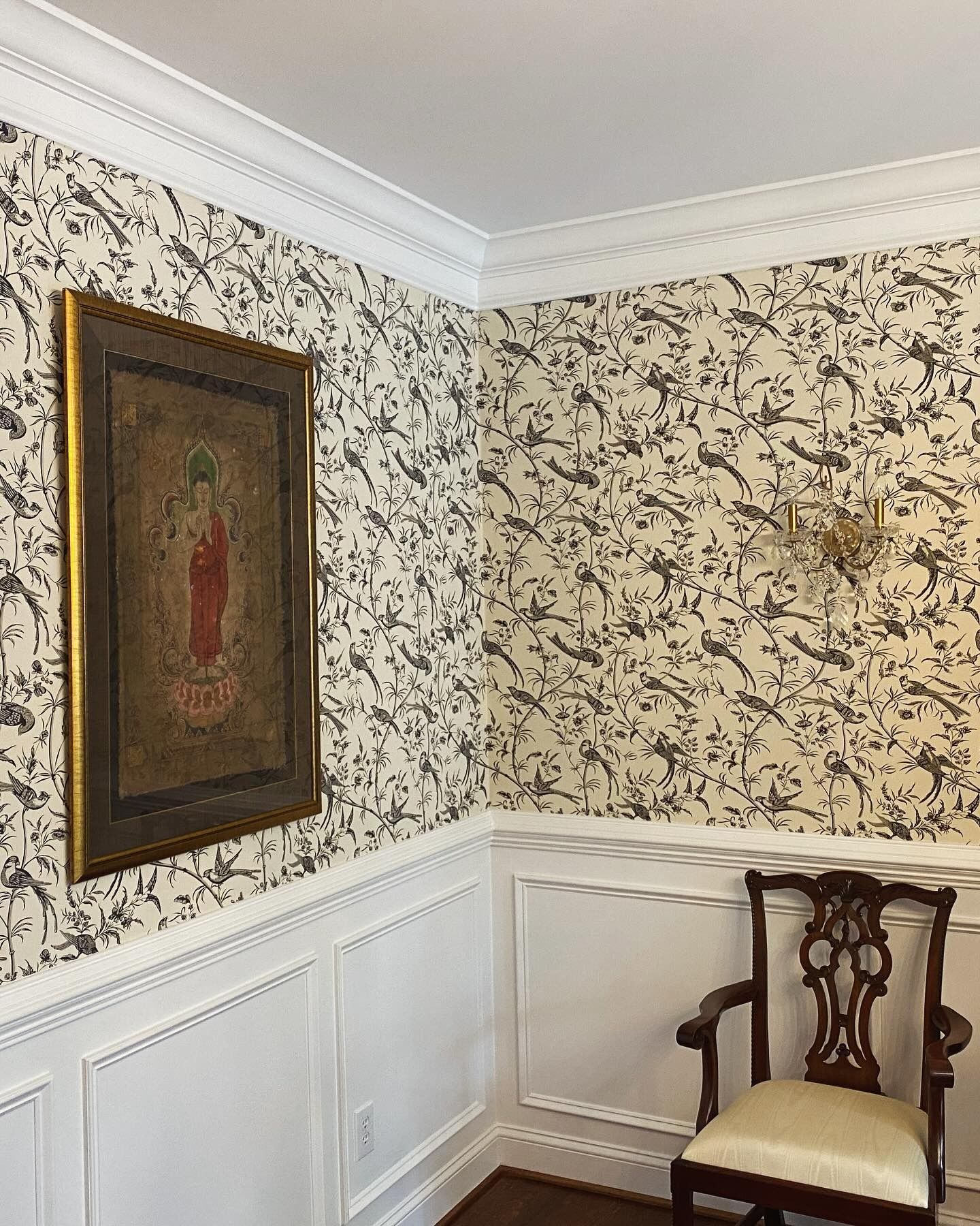 A room with a chair and a painting on the wall