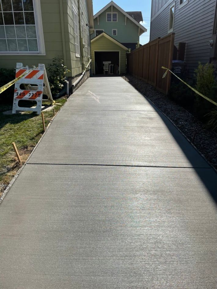 A concrete driveway is being built in front of a house.