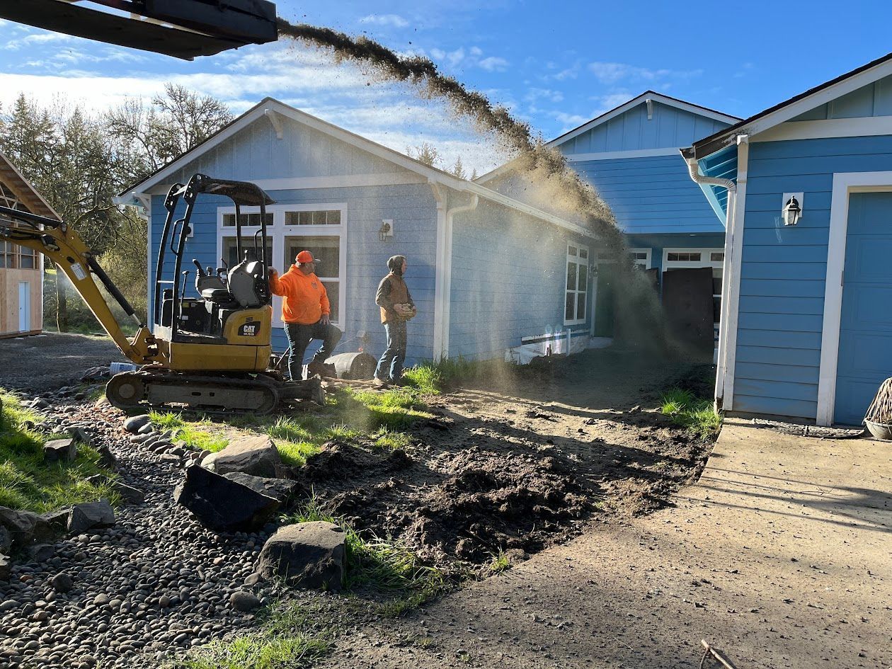 A group of people are working on a driveway in front of a blue house.