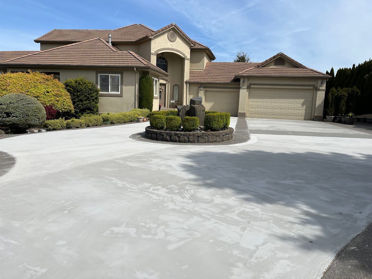 A large house with a concrete driveway in front of it