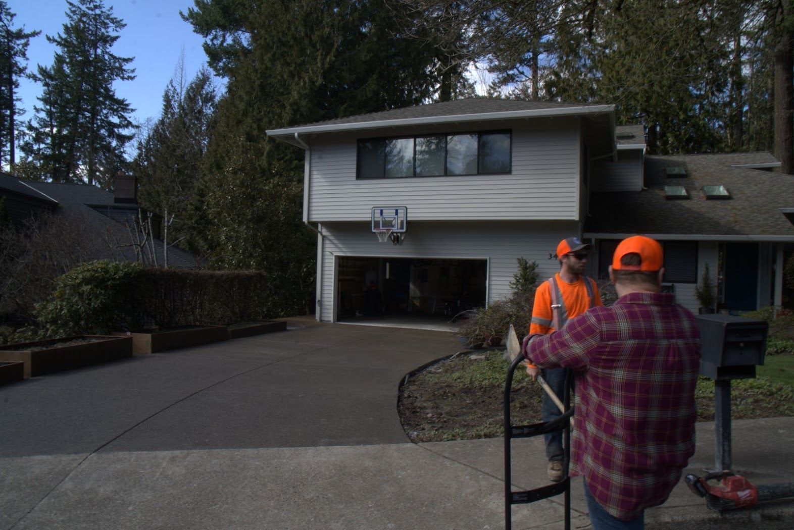 A man is pushing a wheelchair in front of a house