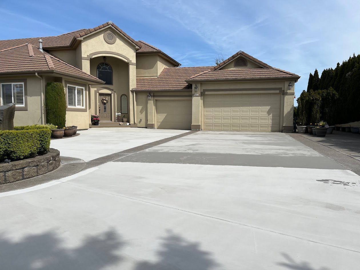 A large house with a concrete driveway in front of it.