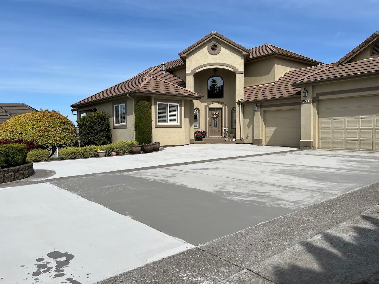 A large house with a concrete driveway in front of it.