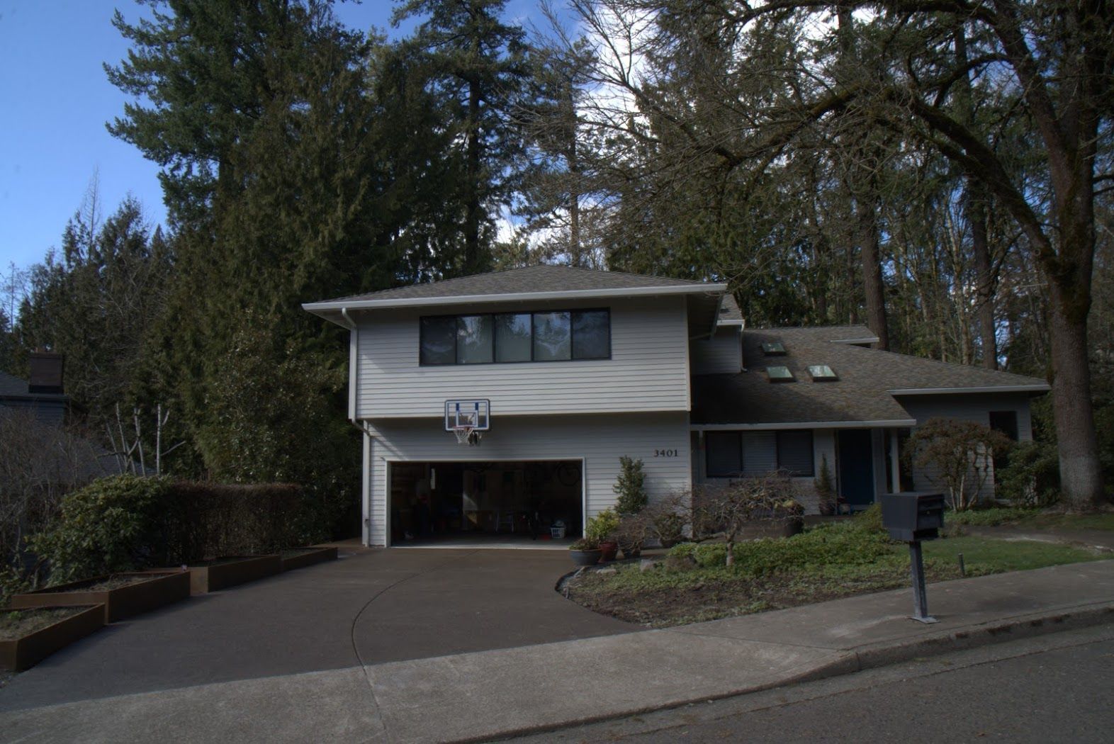 A house with a garage and a mailbox in front of it