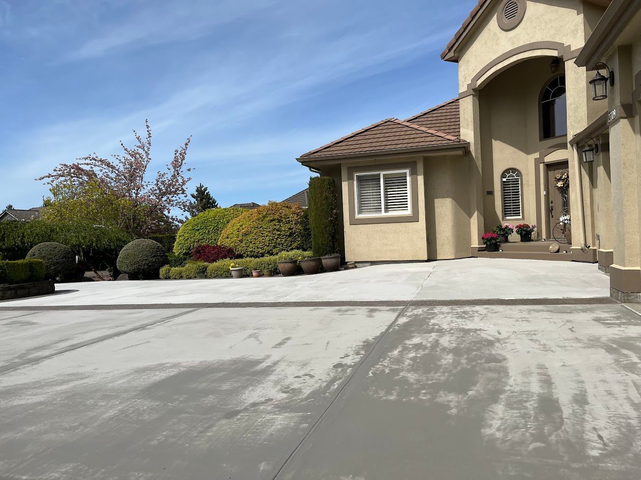 A large house with a concrete driveway in front of it