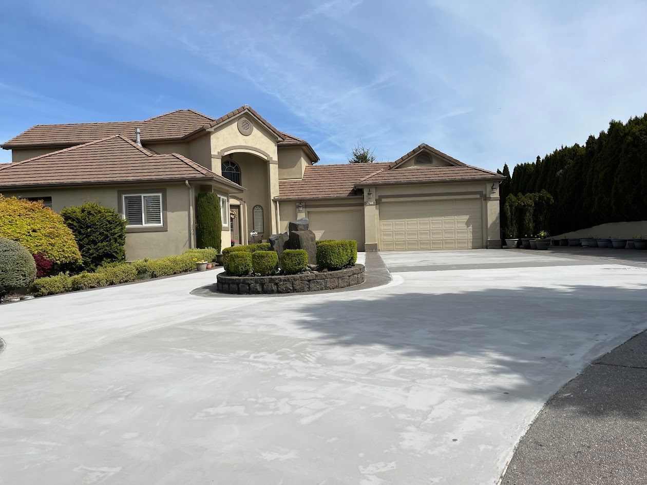 A large house with a concrete driveway in front of it.
