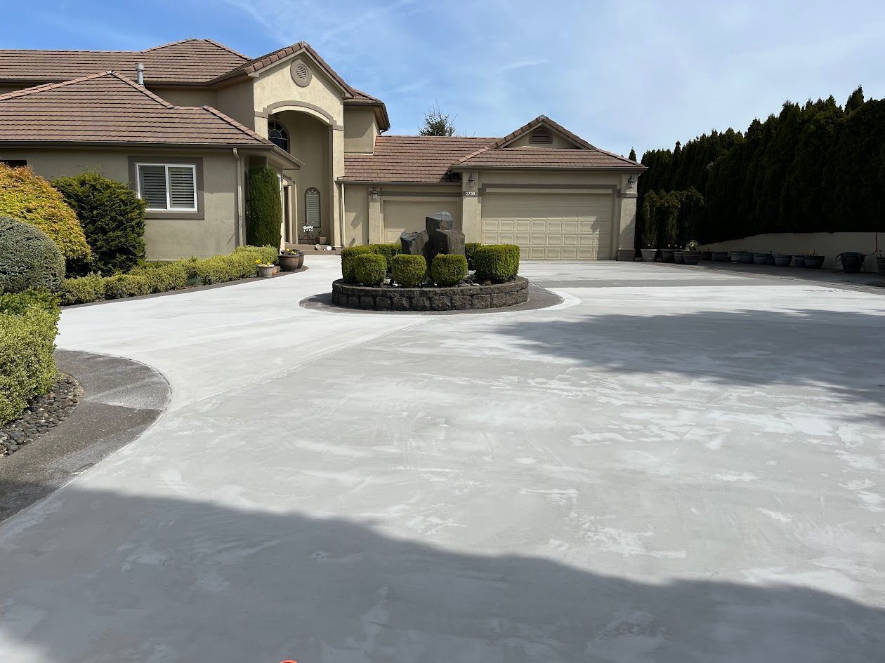 A large house with a concrete driveway in front of it