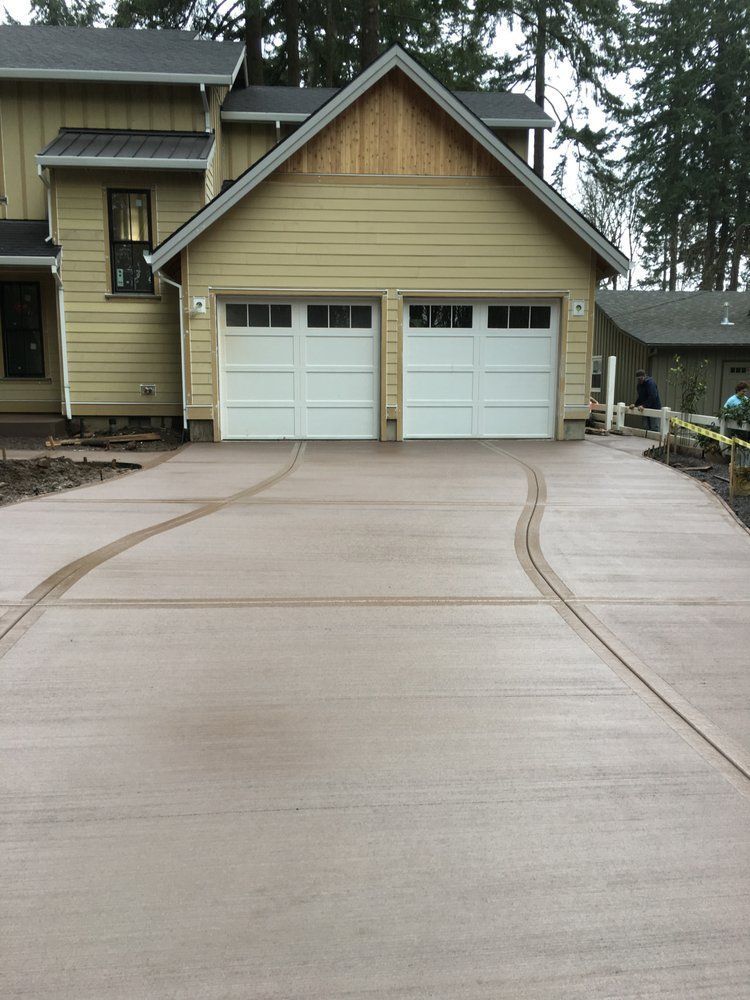 A house with two garage doors and a concrete driveway