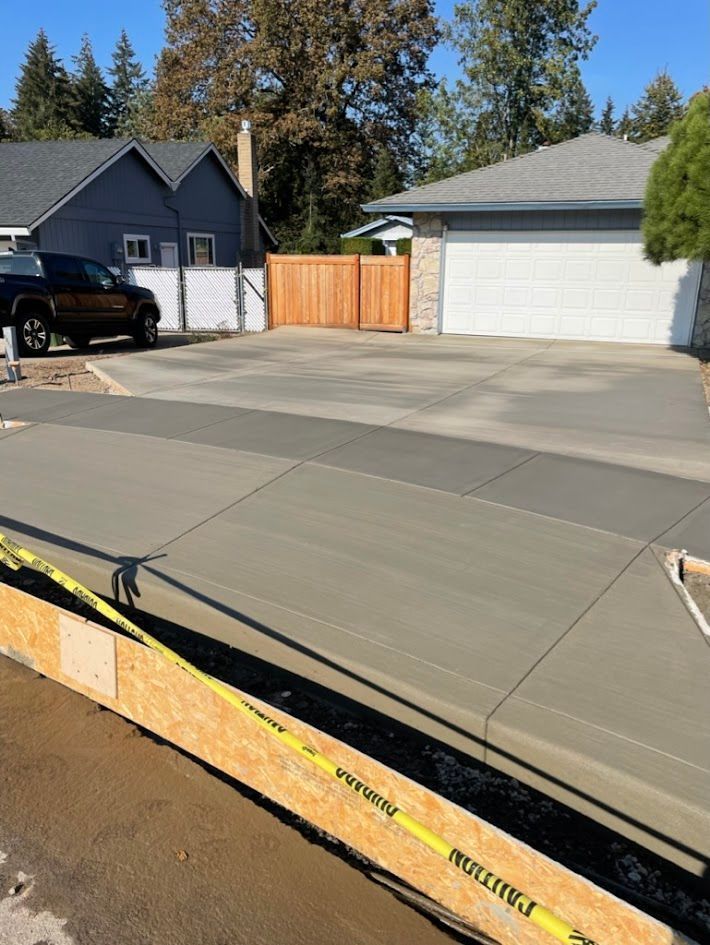 A concrete driveway is being built in front of a house.