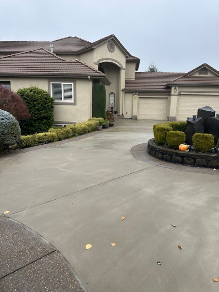 A large house with a large driveway and a fountain in front of it.