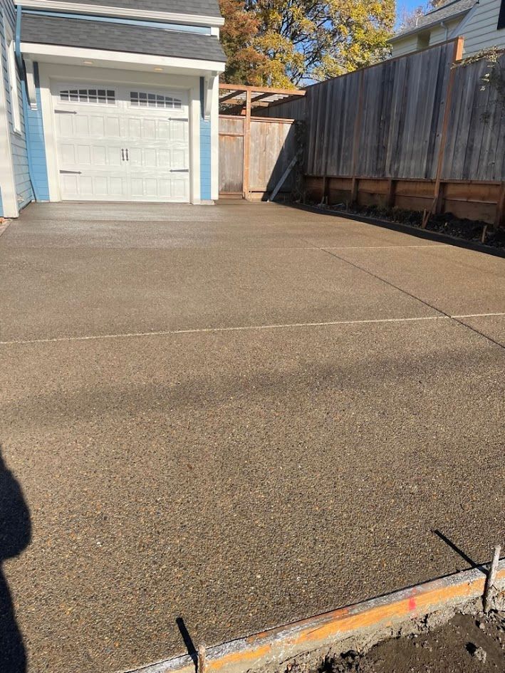 A concrete driveway is being built in front of a house.