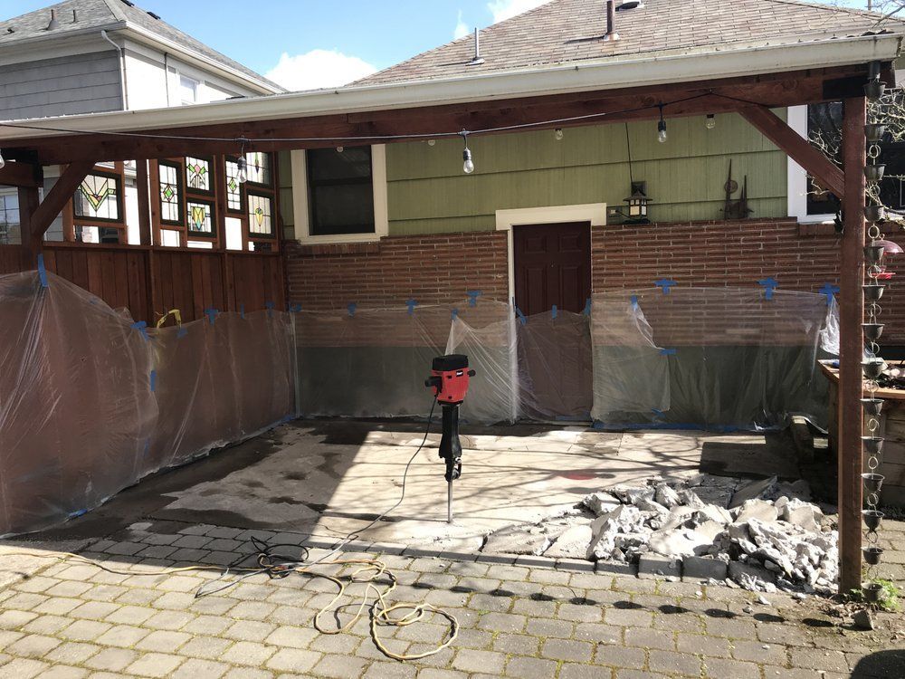 A brick house with a covered patio in front of it.