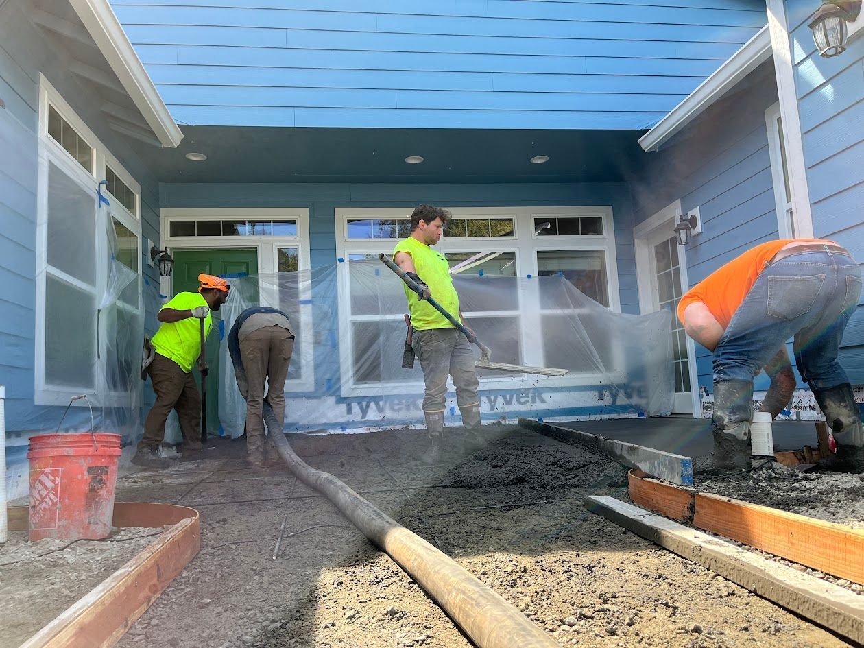 A group of construction workers are working on the side of a house.