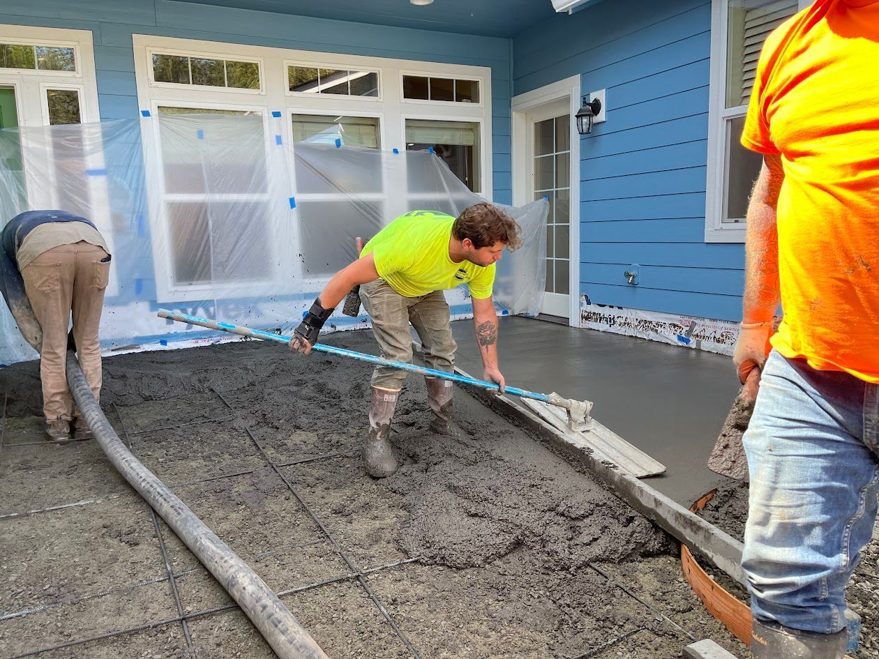 A group of men are working on a concrete patio.