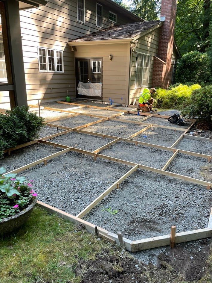 A patio is being built in front of a house.