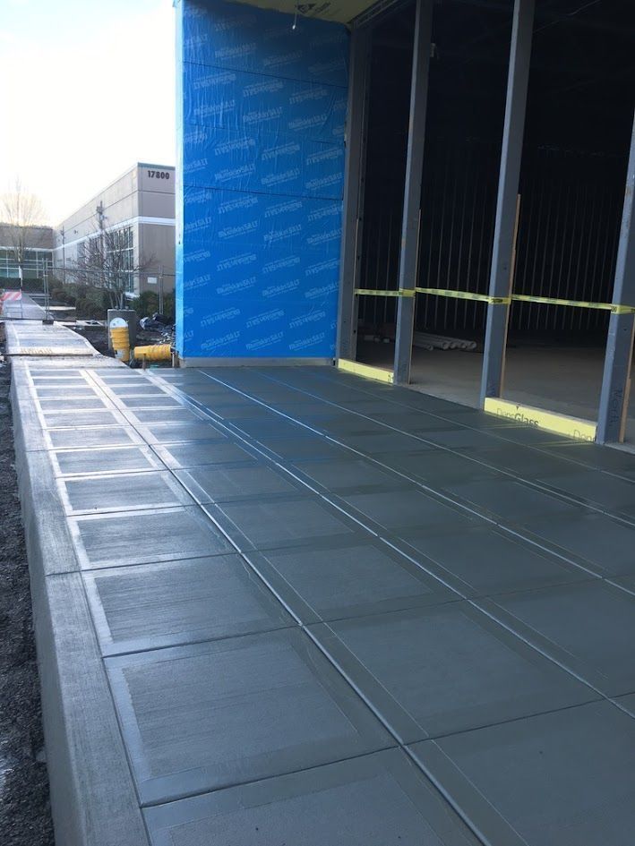 A concrete walkway leading to a building under construction.