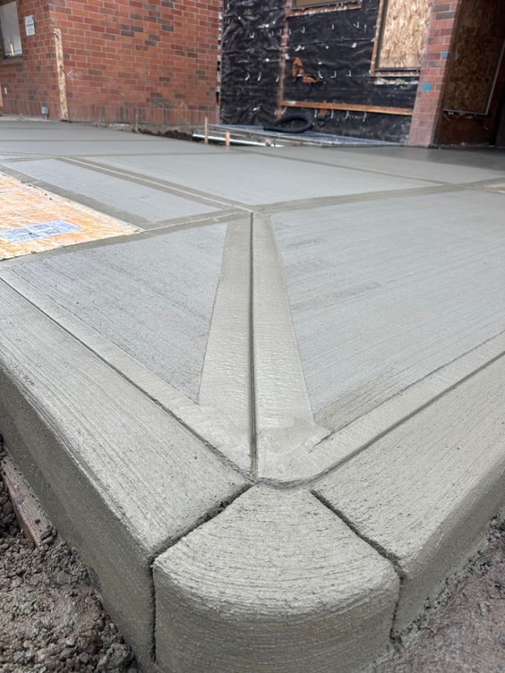A concrete driveway is being built in front of a brick building.