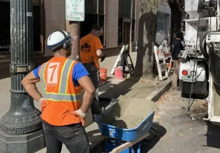 A man wearing an orange vest with the number 7 on it