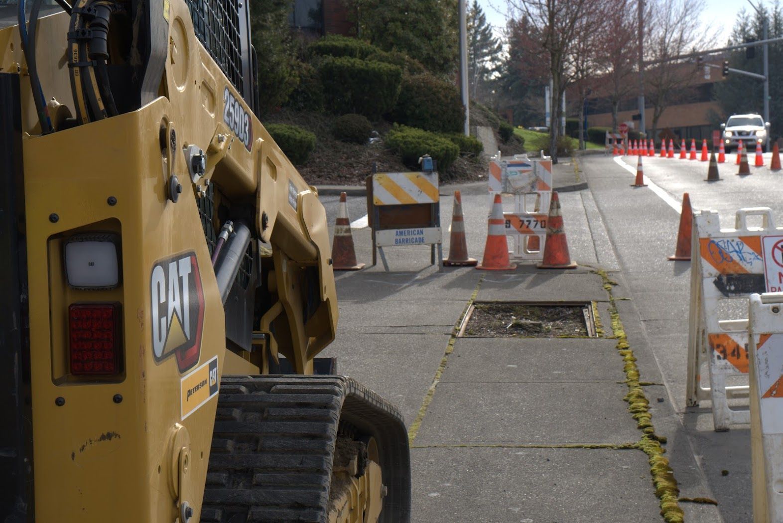 A yellow cat bulldozer is parked on the side of the road